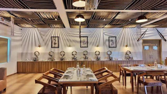 a dinner area with wooden chairs and table at mm resort and spa jim corbett in Uttarakhand hotel_Image