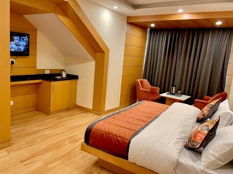 a bedroom with a large bed and two sofa and table at mm retreat in nainital hotel_Image