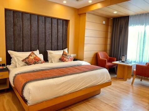 a bedroom with a large bed and two sofa and table at mm retreat in nainital hotel_Image