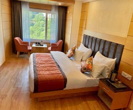 a bedroom with a large bed and two sofa and table at mm retreat in nainital hotel_Image