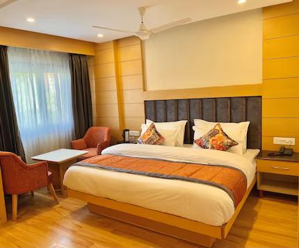 a bedroom with a large bed and two sofa and table at mm retreat in nainital hotel_Image