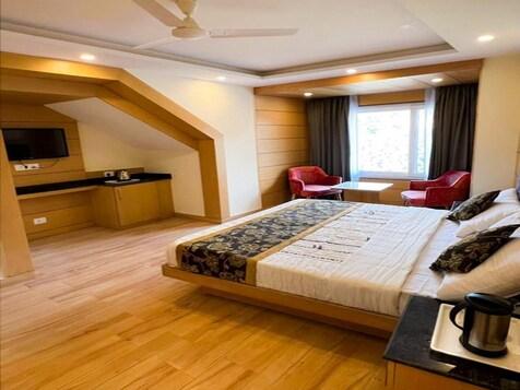 a bedroom with a large bed and two sofa and table at mm retreat in nainital hotel_Image