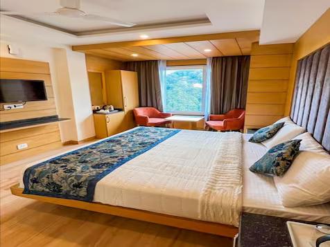 a bedroom with a large bed and two sofa and table at mm retreat in nainital hotel_Image