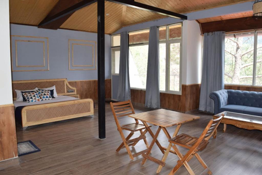 a bedroom with a large bed and sofa at pinewood nirvana shoghi in shimla hotel_Image