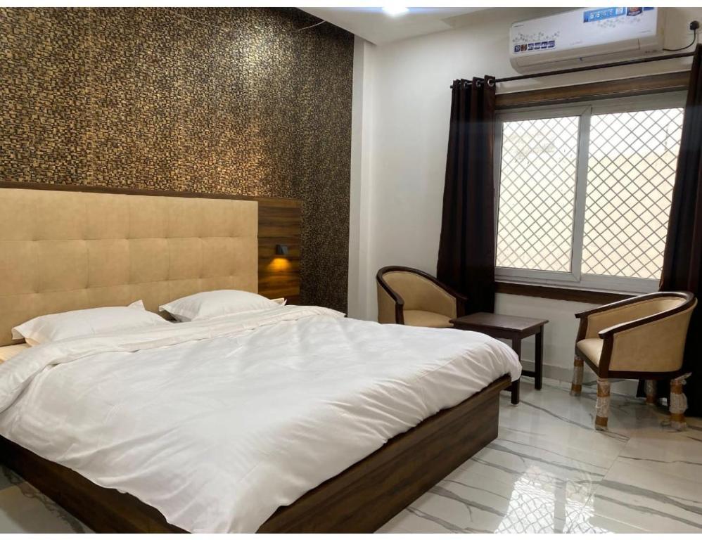 a bedroom with a large bed and two sofa at rajwada hotel in mathura hotel_Image