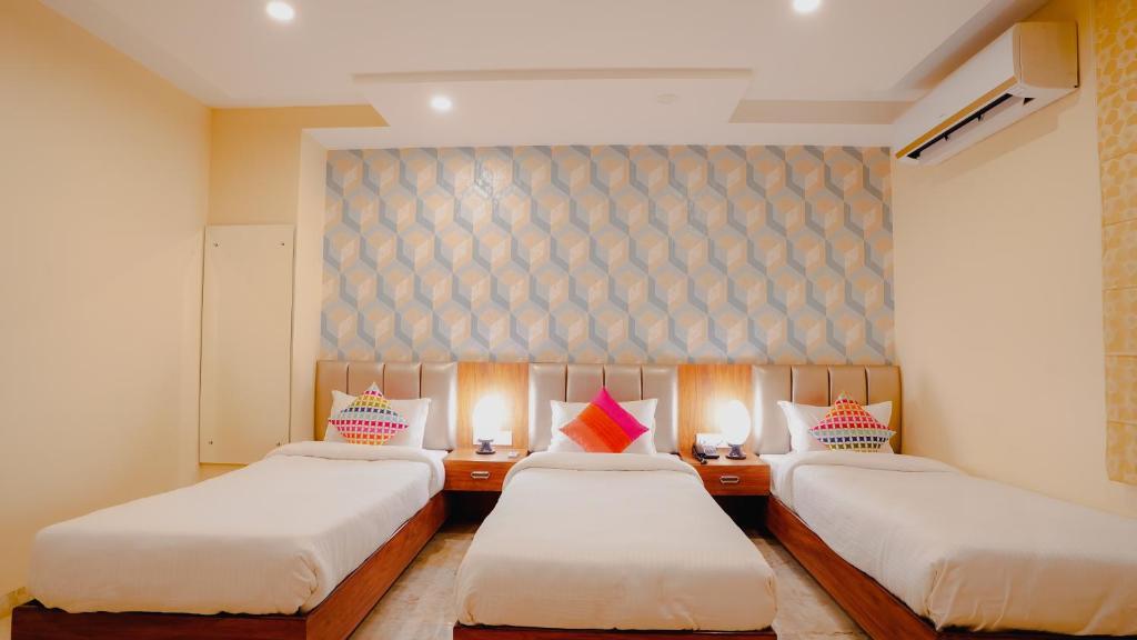 a bedroom with three single bed at sanskar prime hotel in jaipur hotel_Image
