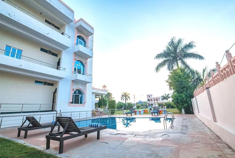 a swimming pool in the middle of building with trees at sidhhi vinayak in ranthambore hotel_Image