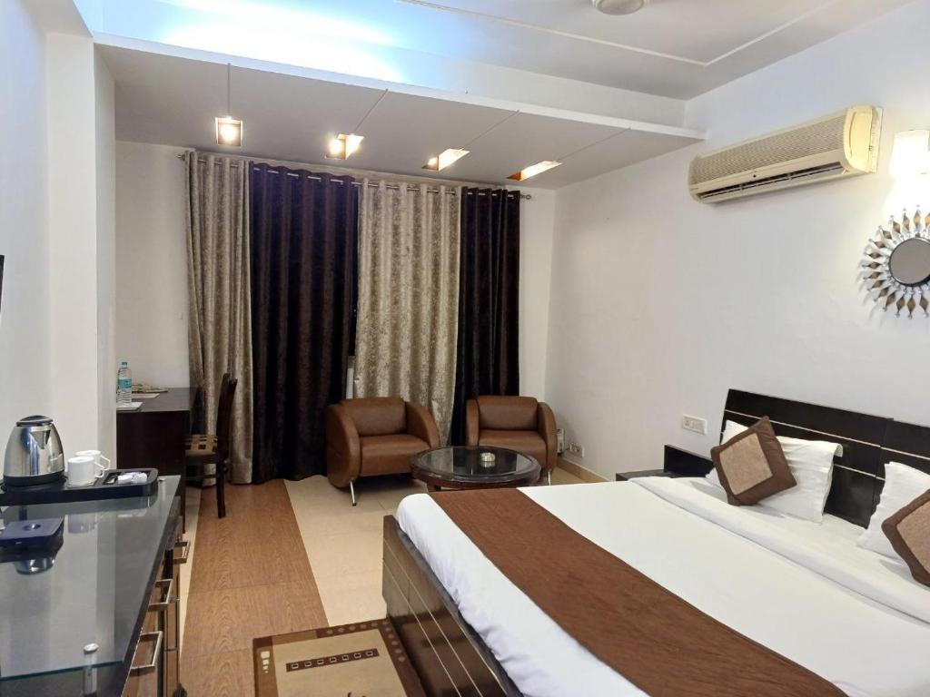 a bedroom with sofa and table at skylark hotel by gabrian hotel in gurugram hotel_Image