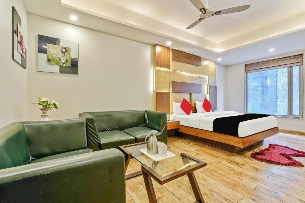 a bedroom with a large bed and sofa at nitya maharani in new delhi hotel_Image
