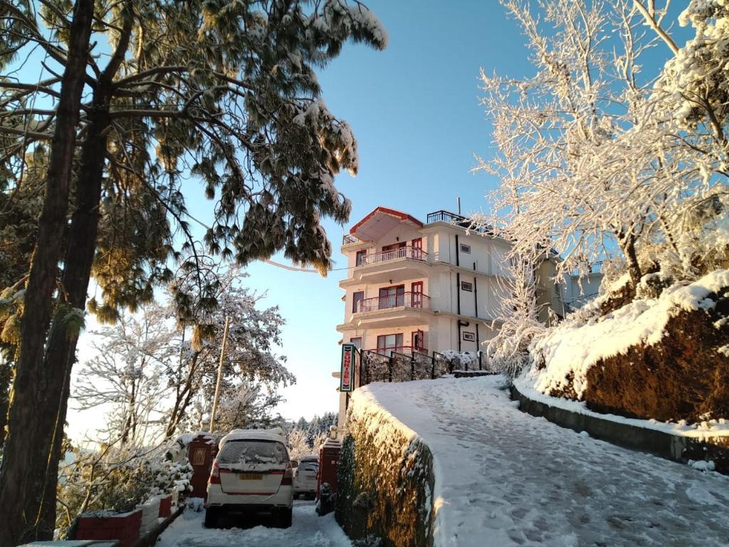 a building with a car parked in front of it at sunrise villa in shimla hotel_Image