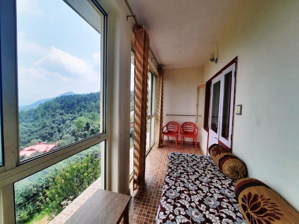 a balcony with a view of the mountains at sunrise villa in shimla hotel_Image