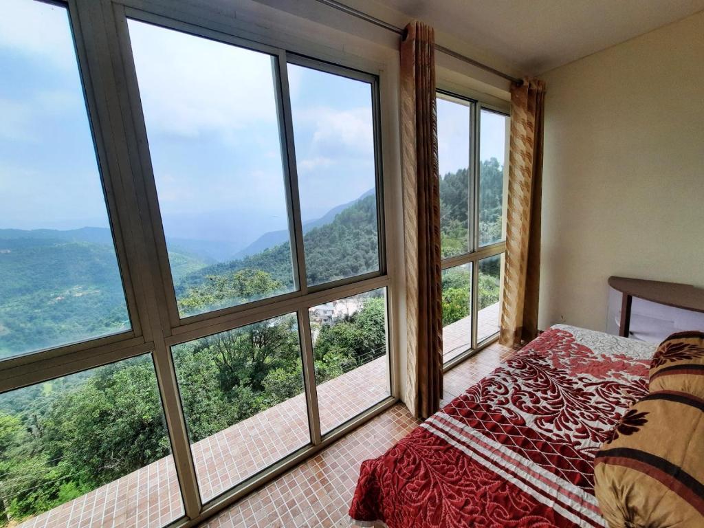 a balcony with a view of the mountains at sunrise villa in shimla hotel_Image