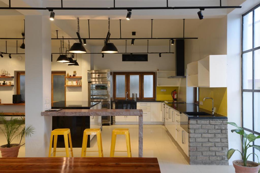 a hotel with kitchen area and stool at the thc backpackers in jodhpur hotel_Image