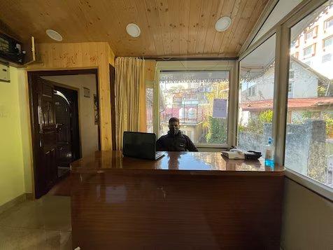 a men stand on reception area with entry gate at the haritage hotel in shimla hotel_Image