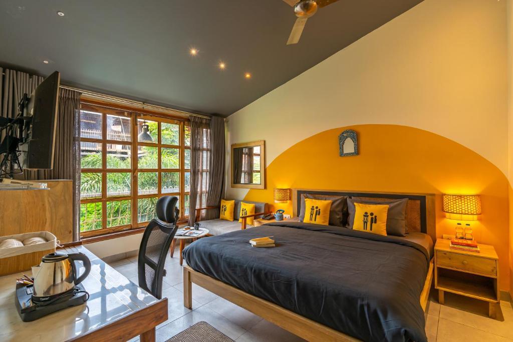a bedroom with a large bed and chair at the artist house in udaipur hotel_Image
