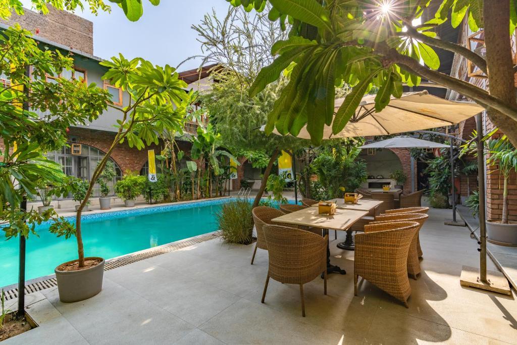 a swimming pool in middle of building with wooden sofa and table at the artist house in udaipur hotel_Image