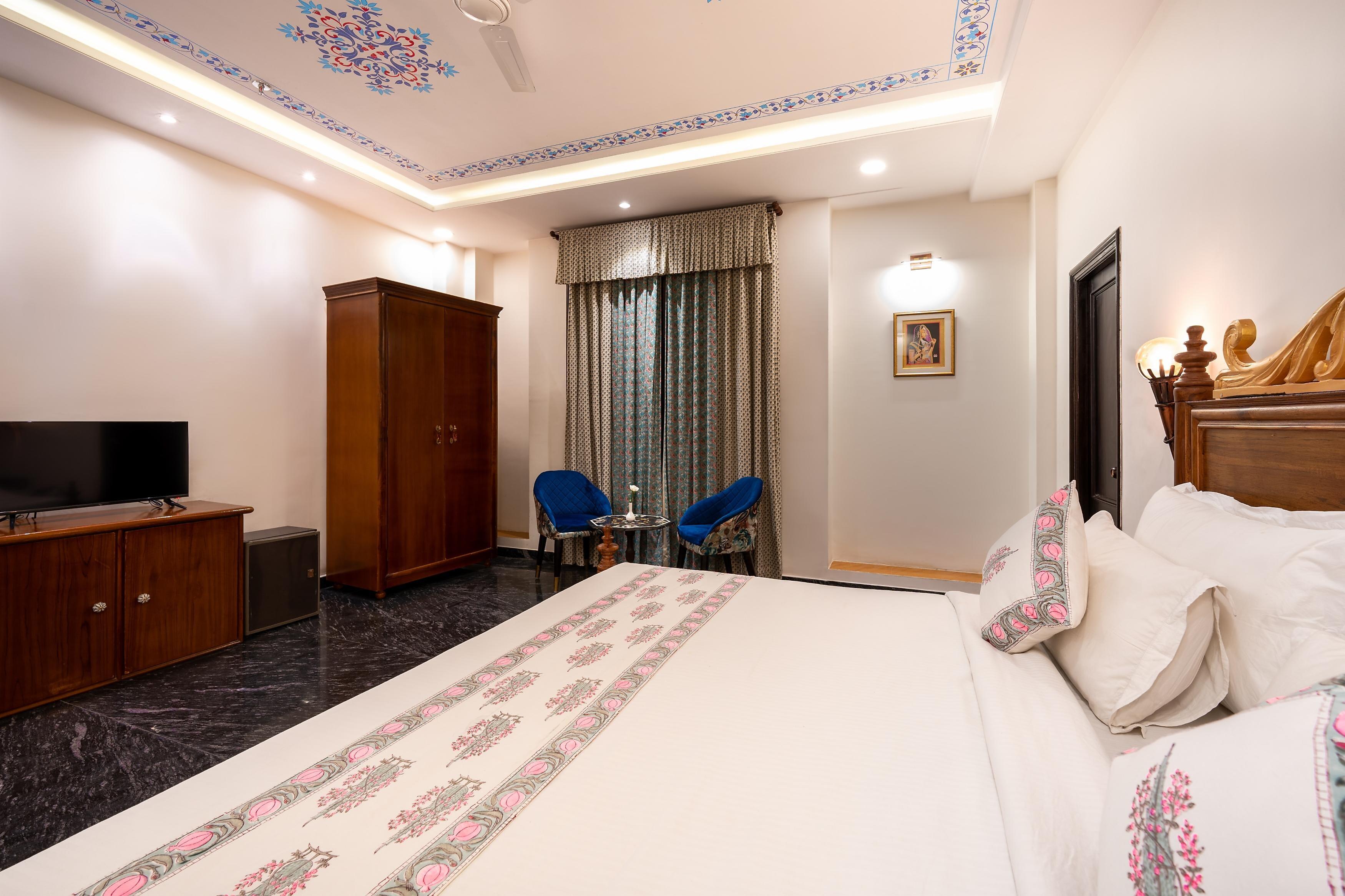 a bedroom with a large bed and tv at the chronicles hotel in udaipur hotel_Image