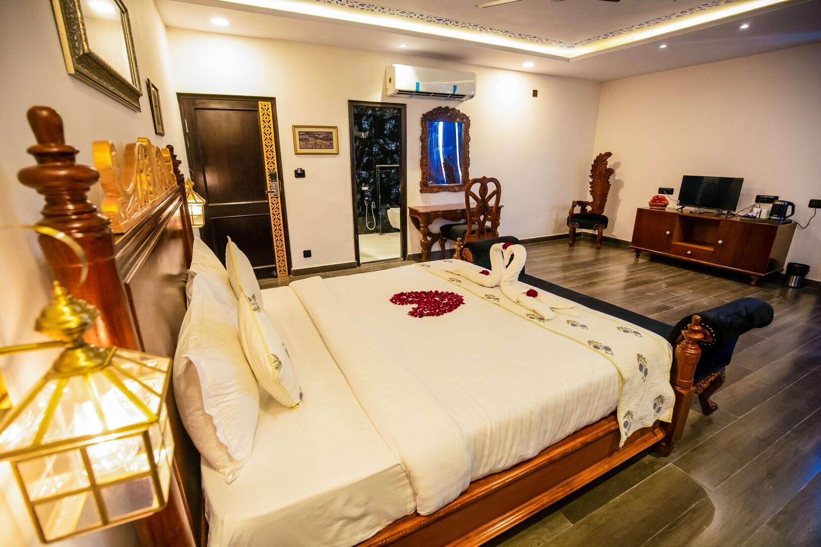 a bedroom with a large bed and a tv at the chronicles hotel in udaipur hotel_Image