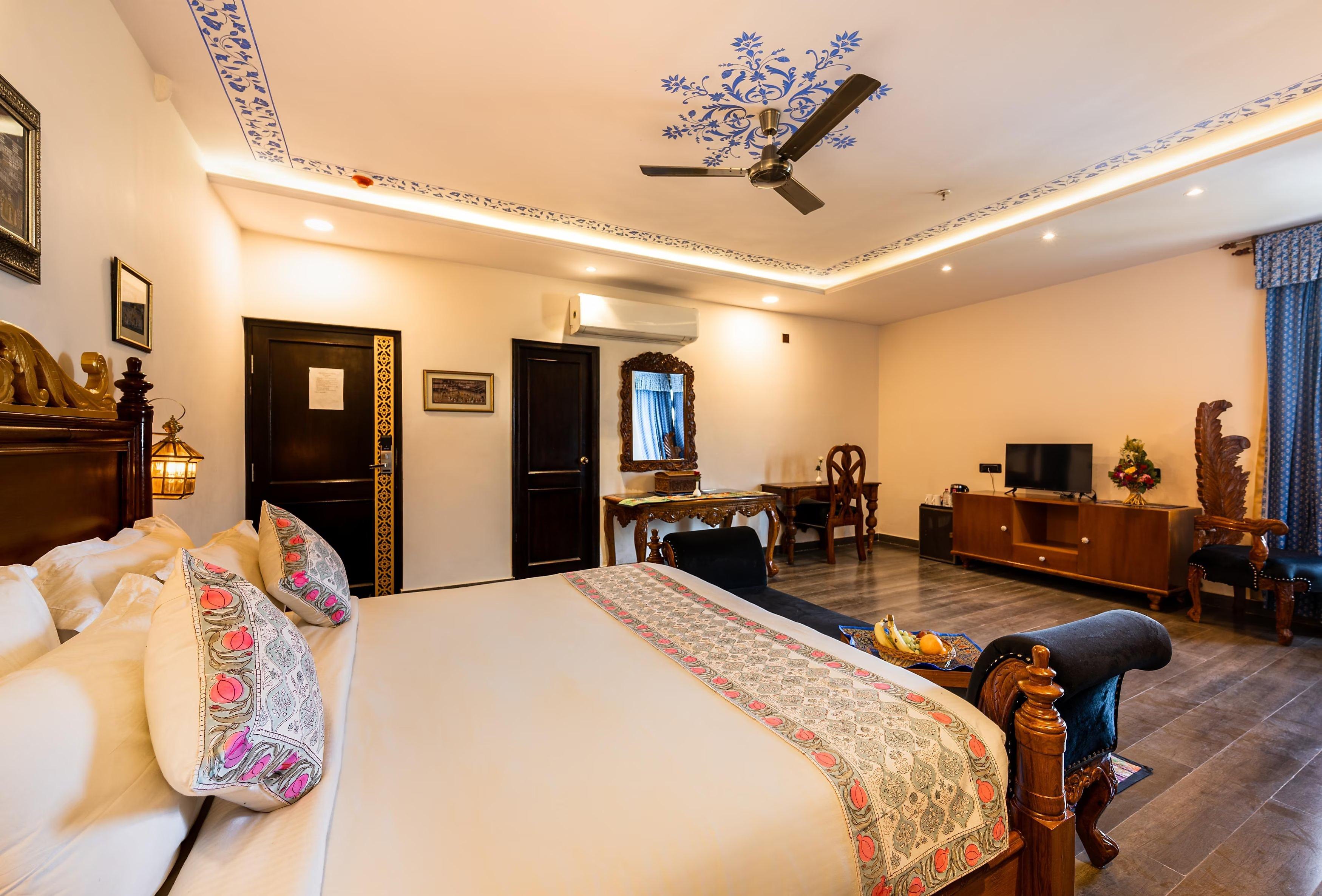 a bedroom with a large bed and tv at the chronicles hotel in udaipur hotel_Image