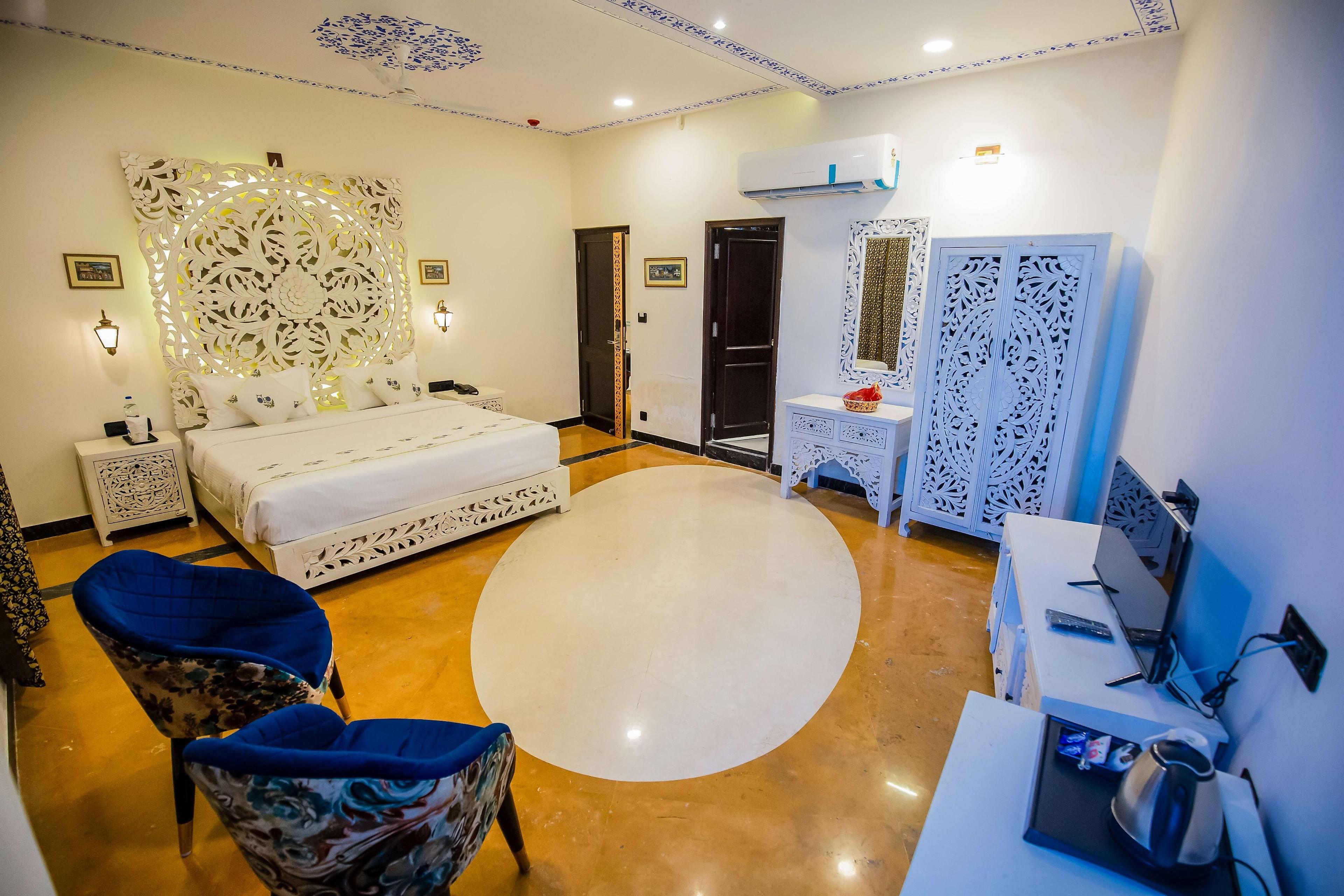 a amazing room with a tv and couches at a bedroom with a large bed and tv at the chronicles hotel in udaipur hotel_Image