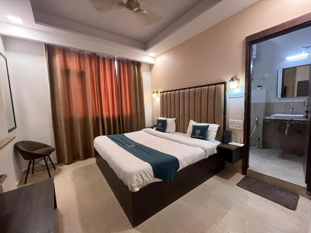 a bedroom with a large bed and bathroom side at the divine oak in katra hotel_Image