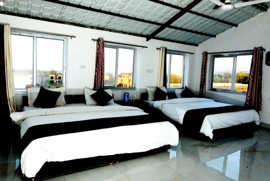 a bedroom with a two double bed and a window view at the forest view in ranthambore hotel_Image
