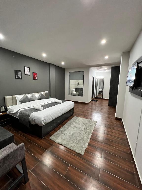 a bedroom with a large bed and a sink a tv at the getway in shimla hotel_Image