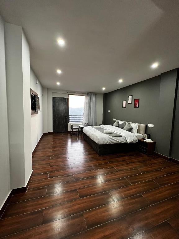 a bedroom with a large bed and window view at the getway in shimla hotel_Image