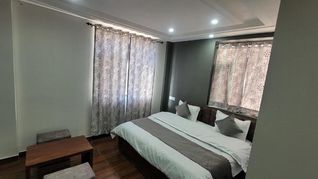a bedroom with a large bed and a table at at the getway in shimla hotel_Image