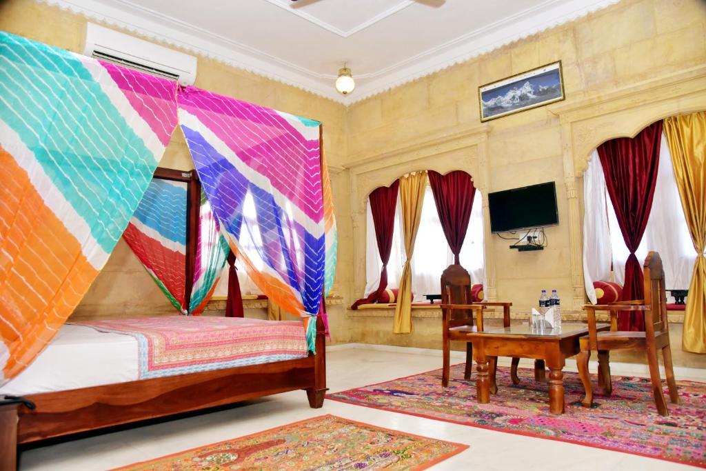 a bedroom with chair and table at the jaigarh palace in Jaisalmer hotel_Image