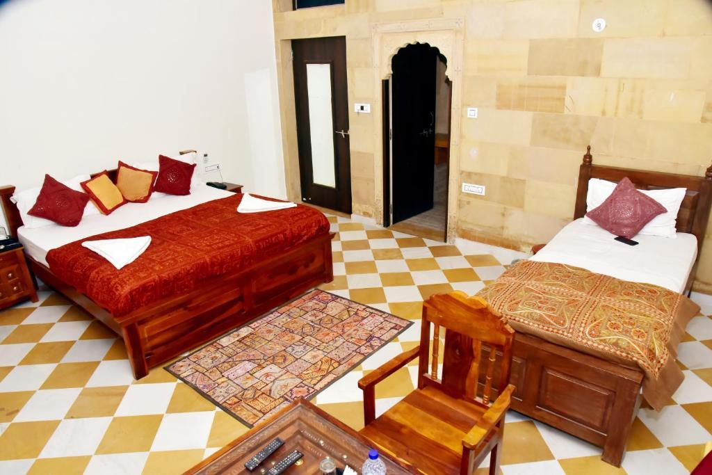 a bedroom with two bed and a chair at the jaigarh palace in Jaisalmer hotel_Image