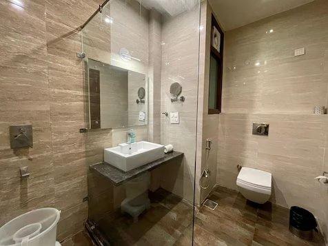 a bathroom with a toilet and a sink at travok resort and spa in mussoorie hotel_Image