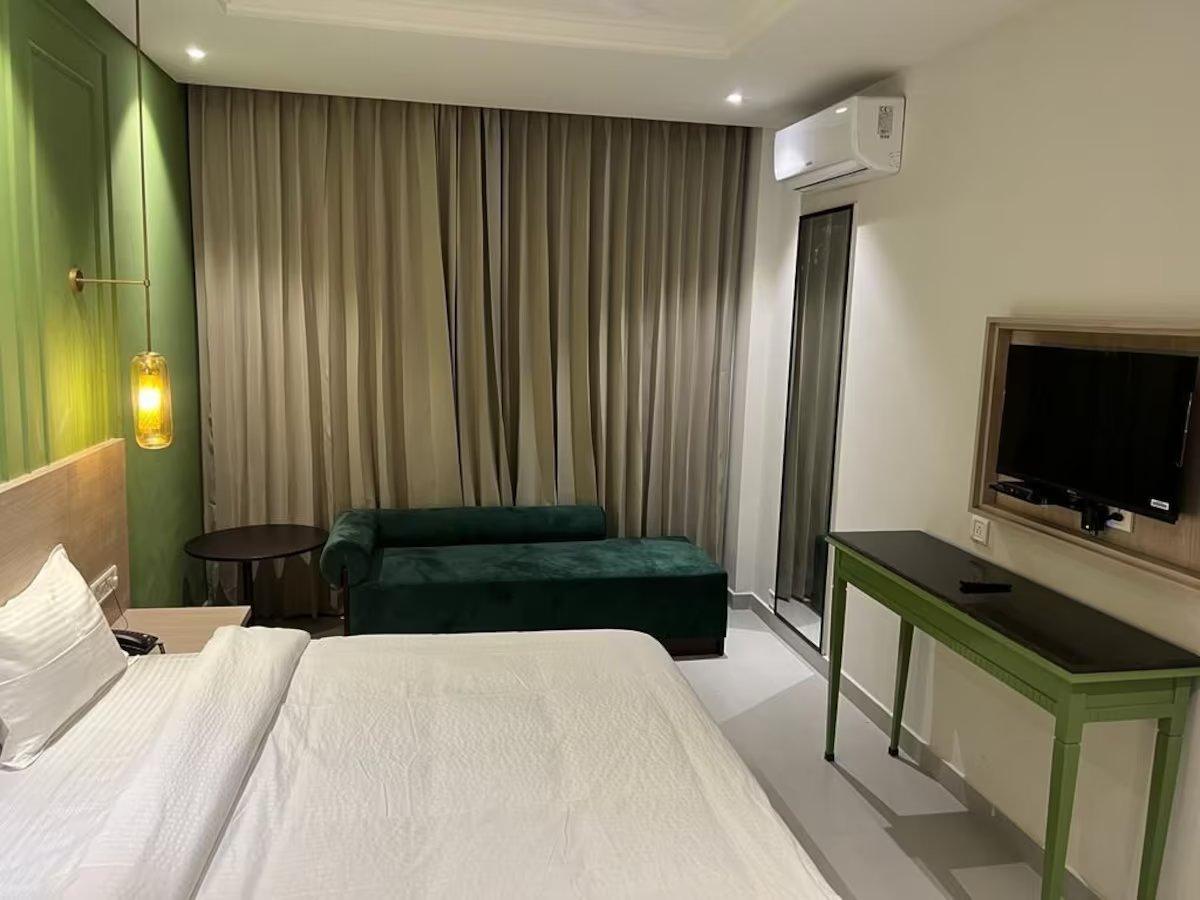 a hotel bedroom with sofa & tv at wonder hill hotel in haridwar hotel_Image