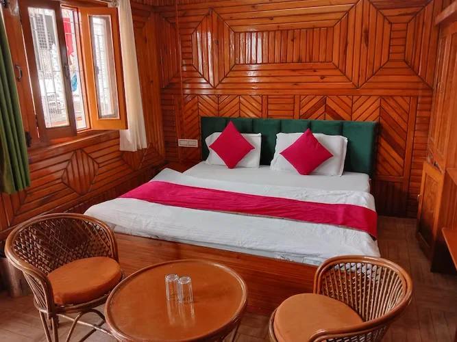 a bed room with chair at hill view in nainital hotel_Image