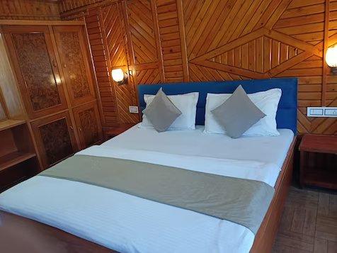 a bed room with chair at hill view in nainital hotel_Image