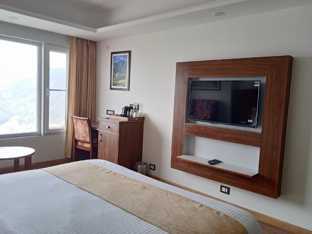 a double bed room with t.v at hotel greenfield regency in shimla hotel_Image