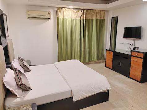 a bedroom with a tv and table at stay n move in indirapuram hotel_Image