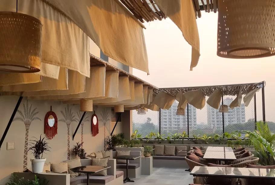 a hotel roof with dinner table and sofa at thor hotel in agra hotel_Image