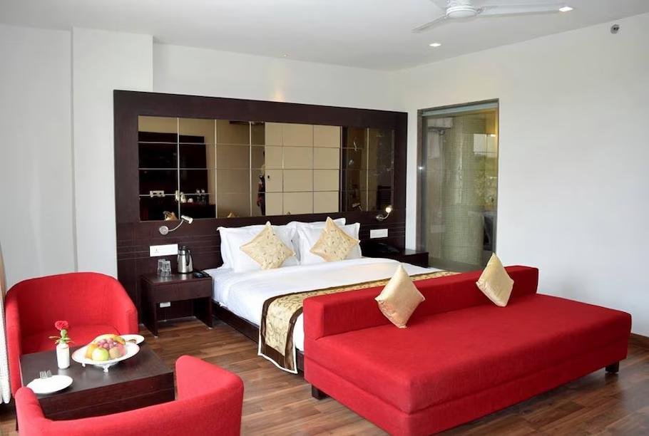 a hotel bedroom with sofa & table and decorations at vesta grand central in Udaipur hotel_Image